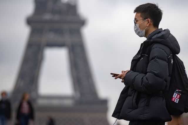 Pedestrians wearing face masks walk near the Eiffel Tower in Paris, November 17th, 2021.